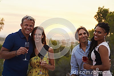 Two happy adult couples socialising outdoors look to camera Stock Photo