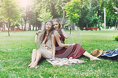 Two happy boho chic stylish girlfriends picnic in park Stock Photo