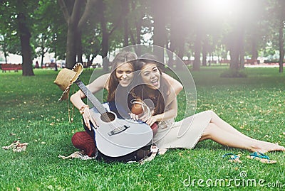 Two happy boho chic stylish girlfriends picnic in park Stock Photo