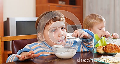 Two happy children eating dairy breakfast Stock Photo