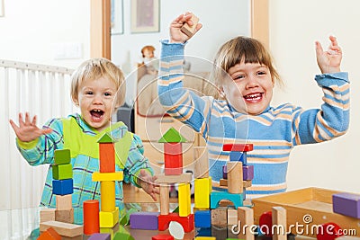 Two happy children playing with blocks in home Stock Photo