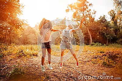 Two happy girls as friends hug each other in cheerful way. Little girlfriends in park. Stock Photo