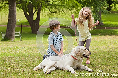 Two happy kids with pet dog at park Stock Photo