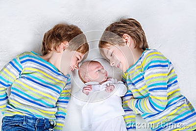 Two happy little preschool kids boys with newborn baby girl Stock Photo