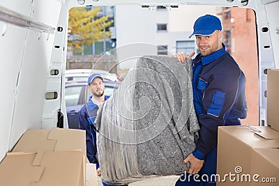 Two Movers Unloading Furniture From Truck Stock Photo