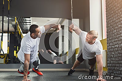 Two happy men fitness workout together at gym Stock Photo