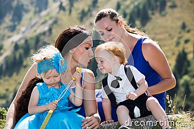 Two happy moms and children girl and boy hugging on nature Stock Photo