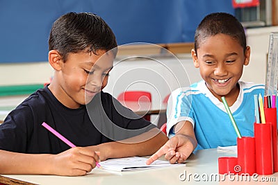 Two happy school boys sharing learning in class Stock Photo