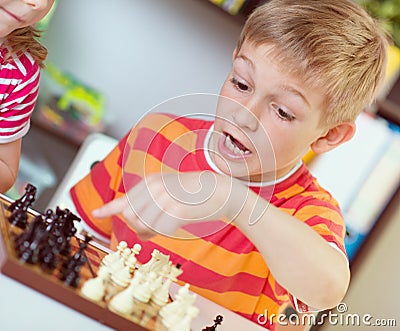 Two happy siblings playing chess Stock Photo