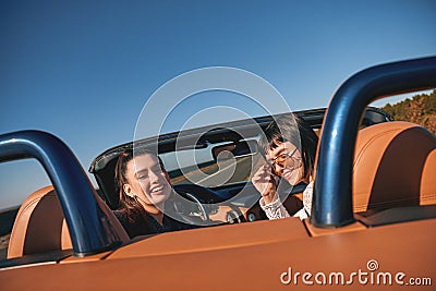 Two happy women in the cabriolet driving and having fun. Rear view Stock Photo