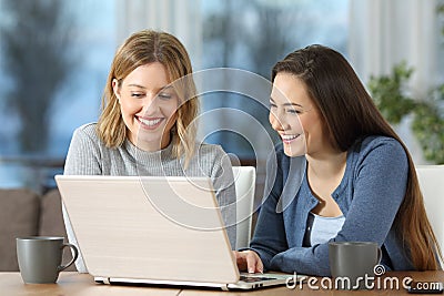 Women watching media content on line in a laptop at home Stock Photo