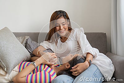 Two happy young aisan casual women having fun on couch at home. Lesbian millennial couple. gbt, homosexual, lesbian Stock Photo