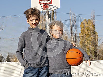 Two happy young boys on basketball field outdoors on a sports ball Stock Photo