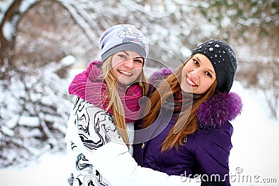 Two happy young girls having fun in winter park outdoors Stock Photo