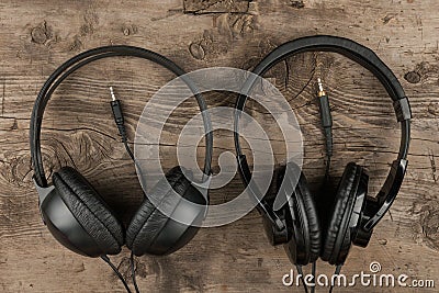 Two headphones and the cord symbolic of a love for music on an antique wooden texture background Stock Photo