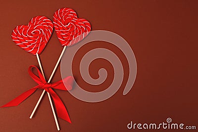 Two heart-shaped candies. Valentine`s day lollipops on brown background. Valentine`s day background, wedding day Stock Photo