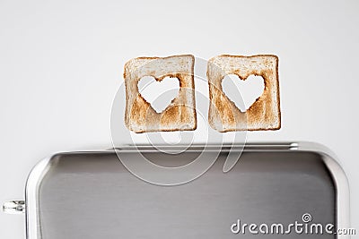 Two Heart shaped on roasted toasted bread in a toaster. Breakfast preparation on Valentine`s Day. symbol sign of love. Stock Photo