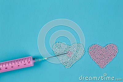 Two hearts of beads and medical syringe, injection, falling in l Stock Photo