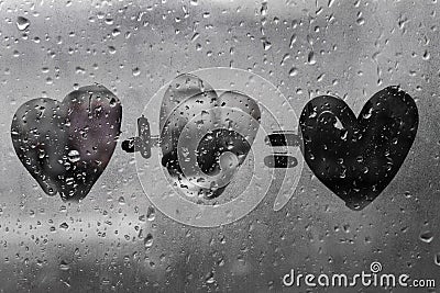 Two hearts with plus sing and equality sign on window in Rainy weather , valentine`s day Stock Photo