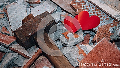 Two hearts among shards next to hammer. Concept of broken love. Unhappy relationships. Difficult period in family life Stock Photo