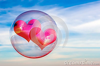 Two hearts in a soap bubble against the sky. Concept of the relationship of a couple in love. Abstract background. Stock Photo