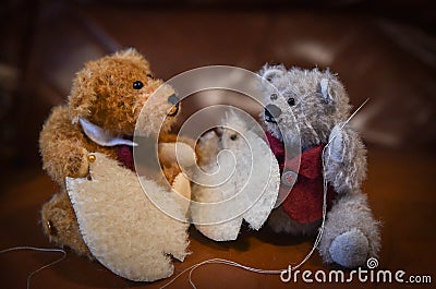 Two miniature home made teddy bears sewing the pattern pieces of another teddy bear Stock Photo