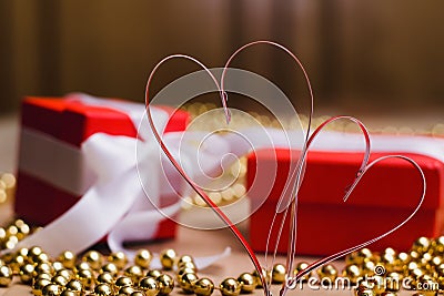 Two homemade paper red hearts and red gift boxes tied with white ribbons Stock Photo