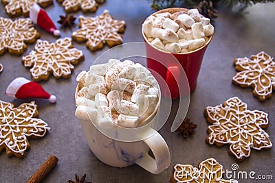 Two hot chocolate cups and marshmallows , against grey background & Christmas composition with Snowflake gingerbread cookies Stock Photo