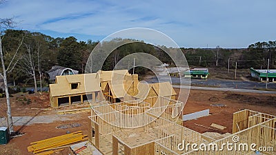Two houses under construction with building envelope and wooden frame beam, joist, trusses framework, gable roof in suburban area Stock Photo