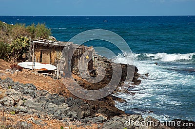 Two huts of palm leaves on the coastline of Crete near Malia Stock Photo