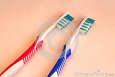 Two hygienic toothbrushes red and blue on colored background Stock Photo