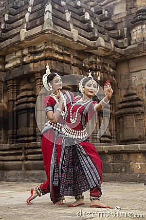 Two Indian classical odissi dancers striking a pose in front of Mukteshvara Temple,Bhubaneswar, Odisha, India Stock Photo