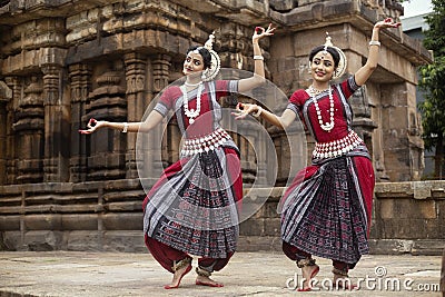Two Indian classical odissi dancers striking a pose in front of Mukteshvara Temple,Bhubaneswar, Odisha, India Stock Photo