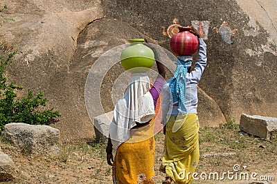 Two Indian women carry water on their heads in pots Editorial Stock Photo