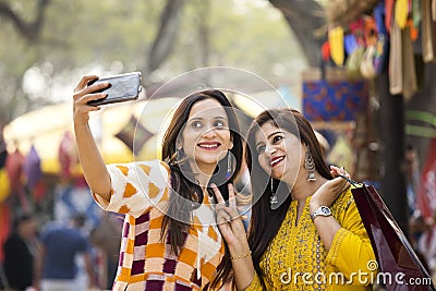 Two women taking selfie at Surajkund Mela Stock Photo