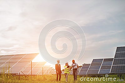 Two inspectors talking with technician at solar station Stock Photo
