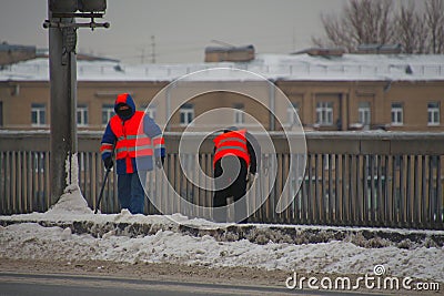 Two janitors cleaning snow on the sidewalk with shovels Editorial Stock Photo