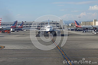 Two JetBlue Jets Taxi Among Parked American Airlines Jets at LAX Editorial Stock Photo