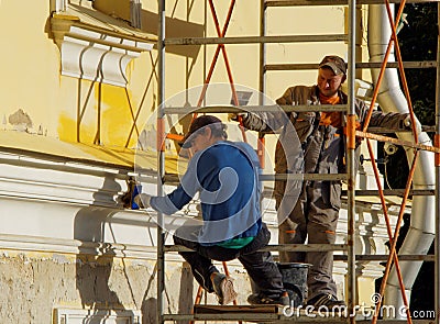 Two jobmans repairing the facade of a building Editorial Stock Photo