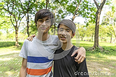 Two joyful teenage boys in the summer park against the blue sky. Stock Photo