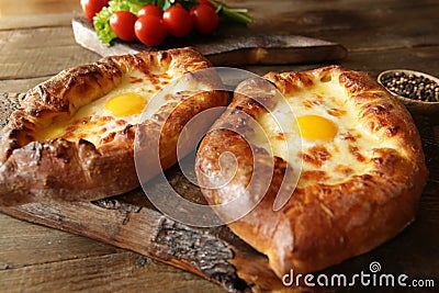 Khachapuri Adjara traditional Georgian dishes. Baked bread stuffed with cheese and eggs. Stock Photo