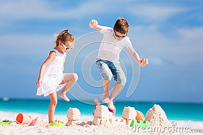 Two kids crushing sandcastle Stock Photo