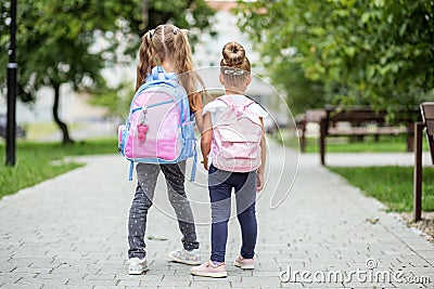 Two kids go to school with backpacks. The concept of school, study, education, friendship, childhood. Stock Photo