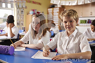 Two kids in a lesson at a primary school look to camera Stock Photo