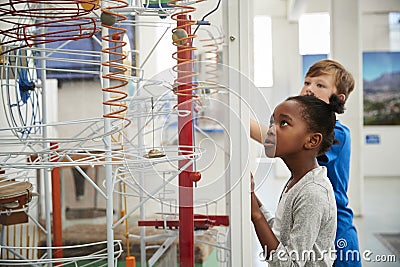 Two kids looking at a science exhibit, waist up Stock Photo