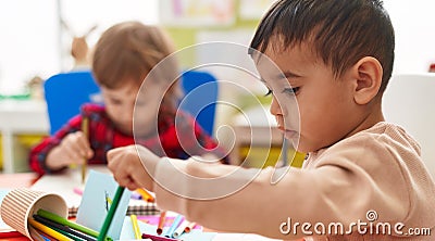 Two kids preschool students sitting on table drawing on paper at kindergarten Stock Photo