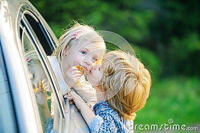 Two kids saying goodbye before car travel. Little boy gives kiss for cute girl. Good bye before car travel. Stock Photo