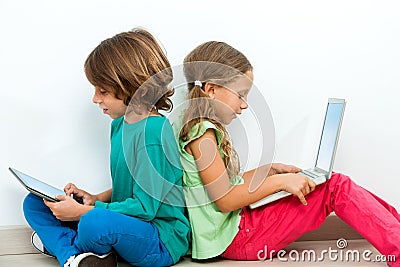 Two kids socializing with laptop and tablet. Stock Photo