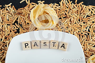 Two kinds of pasta scattered around white plate Editorial Stock Photo