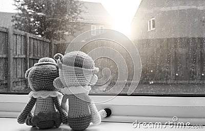 Two knitting dolls boy and girl holding hand sitting next to the window, Black and white colour Stock Photo